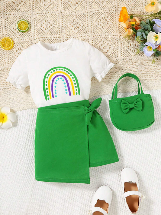 Set for young girls including a tee with rainbow print, a skirt with bow front and asymmetrical hem, and a matching bag.