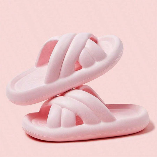 Thick sole bathroom slippers for women with slip-resistant and wear-resistant features, designed with crossed straps. Available in pink.